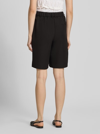 Frauenmodel trägt Regular Fit Chinoshorts mit Viskose-Anteil Modell 'KAMIL' von Pieces, Optik: Unifarben, Materialverarbeitung: Twill, Ganzkörperansicht Rückansicht.