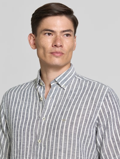 Männermodel trägt Regular Fit Freizeithemd mit Button-Down-Kragen von Fynch-Hatton, Leinen-Mix, grau-weiß gestreift, Nahaufnahme Oberkörper.