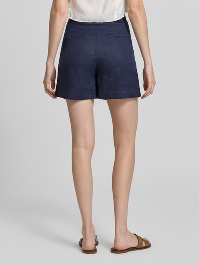 Kobieta nosi Leinenshorts mit Eingrifftaschen od Stefanel z czystego lnu, krój straight fit, kolor granatowy, długość wewnętrzna nogawki 11 cm, szerokość w rozmiarze 36: 33 cm, widok całej sylwetki od tyłu.