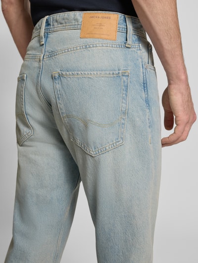 Männermodel trägt Straight Fit Jeans im 5-Pocket-Design Modell 'Chris' von JACK & JONES, Reine Baumwolle, helle Waschung, Ganzkörperansicht Rückansicht.