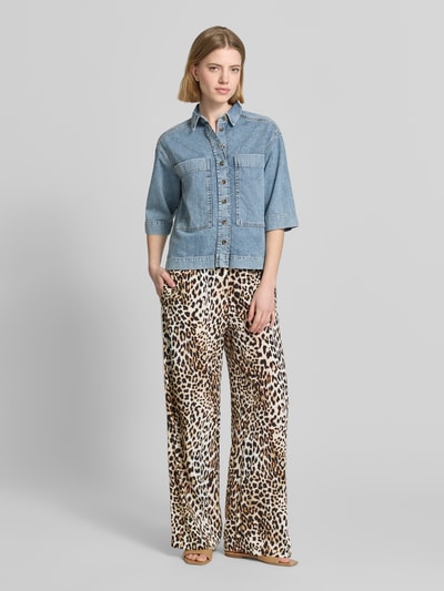 Frauenmodel trägt Hose aus Viskose mit elastischem Bund von Emily Van den Bergh, Relaxed Fit, Allover-Leo-Muster, Ganzkörperansicht von vorne.