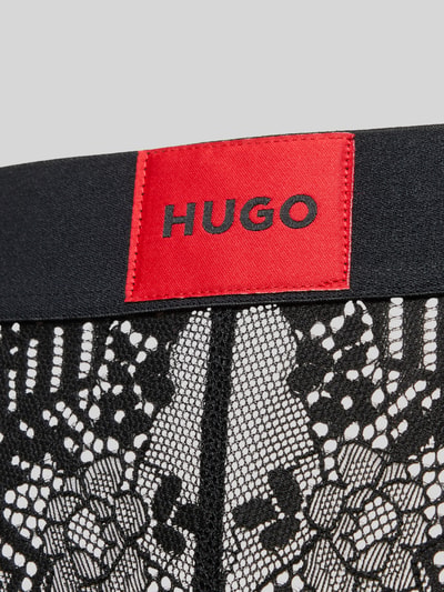 Produktfoto, Slip mit Label Patch Modell 'LACE' von HUGO in schwarzer Semitransparent-Optik mit abstraktem Muster, elastischer Bundabschluss, Materialverarbeitung: Spitze.