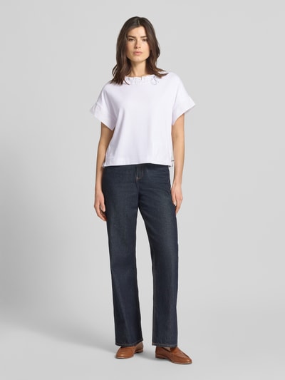 Vrouwenmodel draagt T-shirt met Eingrifftasche am Saum van Marc Cain in wit, mix van katoen en elastaan, los model, ronde hals met tunnelkoord, band met tunnelkoord, ruglengte bij maat 36: 51 cm. Ganzfiguur vooraanzicht.
