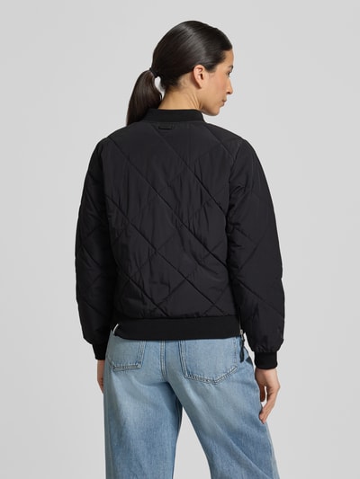Frauenmodel trägt schwarze Steppjacke mit Knopfleiste Modell 'ANGE2' von khujo, Regular-Fit, Stehkragen, Rückansicht, Ganzkörperansicht. Rückenlänge bei Größe S: 59 cm, Schulterbreite: 36 cm, Brustweite: 46 cm, Ärmellänge: 61 cm.