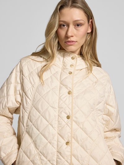 Vrouwenmodel draagt gewatteerd jack met capuchon model 'SRACCONTO' van Marella in regular fit, knoopsluiting, kleur licht beige, maat 36, ruglengte 65 cm, schouderbreedte 39 cm, borstwijdte 55 cm, mouwlengte 59 cm. Nahaufnahme Oberkörper.