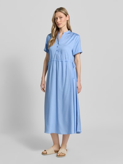 Frauenmodel trägt Midikleid aus Lyocell mit V-Ausschnitt von More & More in Hellblau, A-Linie, Stehkragen, Knopfleiste, Ärmel mit Aufschlag, regulierbares Taillenband, Ganzkörperansicht von vorne. Rückenlänge 123 cm, Brustweite 52 cm, Ärmellänge 21 cm, Größe 36.