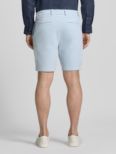 Männermodel trägt Modern Fit Chinoshorts aus Baumwoll-Mix Modell 'KANE1' von BOSS, hellblau, unifarben, Paspeltaschen, Ganzkörperansicht Rückansicht