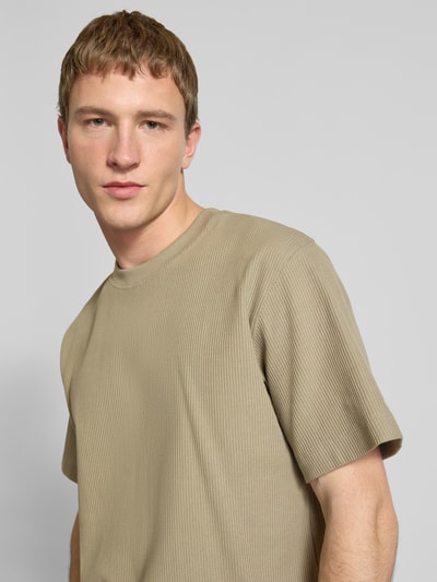 Männermodel trägt T-Shirt mit Ripp-Optik Modell 'HARRISON' von JACK & JONES, reine Baumwolle, lockere Passform, Nahaufnahme Oberkörper.