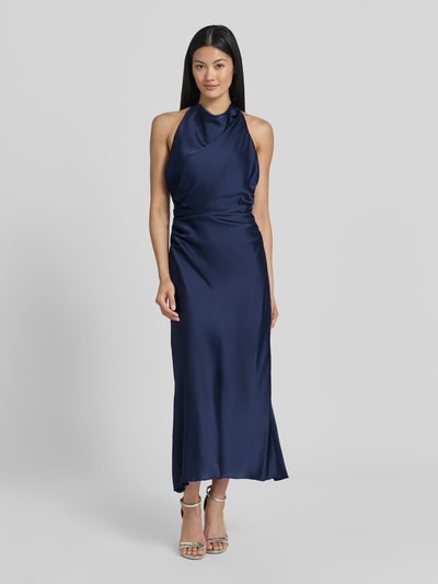Modelka kobieca nosi Knielanges Cocktailkleid aus Satin od Hey Kyla, ciemnoniebieski satynowy materiał, krój slim fit, bez rękawów, drapowania, długość do kolan, elastyczna tkanina, Szerokość w rozmiarze 36: 38 cm, długość tyłu 97 cm, widok całej sylwetki z przodu.