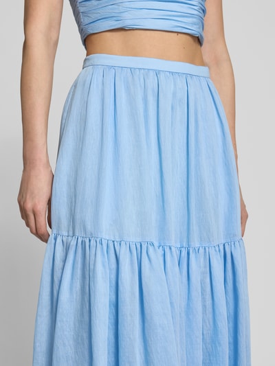 Frauenmodel trägt Maxirock mit Volantsaum und seitlichem Reißverschluss von Jake*s Cocktail in Hellblau, A-Linie, Nahaufnahme Oberkörper.