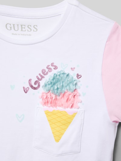 Mädchen trägt Regular Fit T-Shirt mit Logo-Print von Guess, weiß und rosa, Eiscreme-Motiv, Baumwoll-Mix, Nahaufnahme Oberkörper