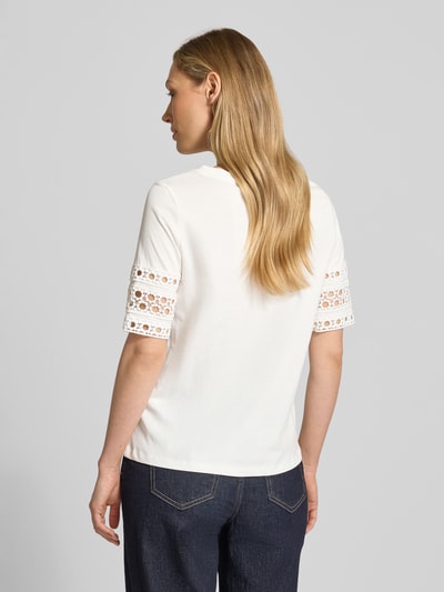Frauenmodel trägt Regular Fit T-Shirt aus reiner Baumwolle Modell 'IVACY' von Vero Moda, unifarben, Lochstickerei an Ärmeln, Ganzkörperansicht Rückansicht.