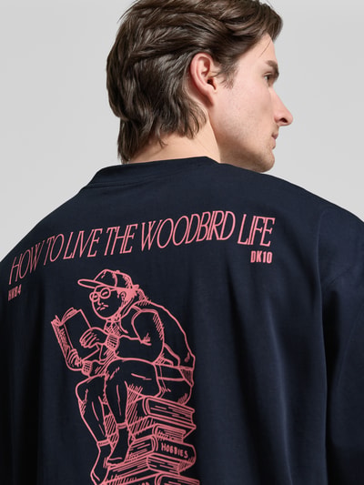 Männermodel trägt T-Shirt mit Label-Print Modell 'Beam' von WOODBIRD, reine Baumwolle, lockerer Schnitt, Rückenansicht, Nahaufnahme Oberkörper
