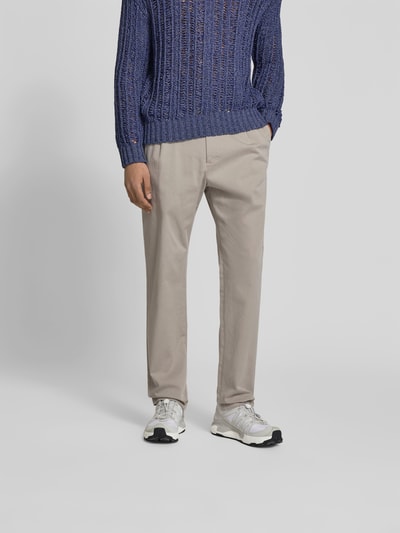 Männermodel trägt Slim Fit Stoffhose mit Tunnelzug von Closed, Baumwoll-Mix in Beige, seitliche Eingriff- und Gesäßtaschen, Ganzkörperansicht von vorne.