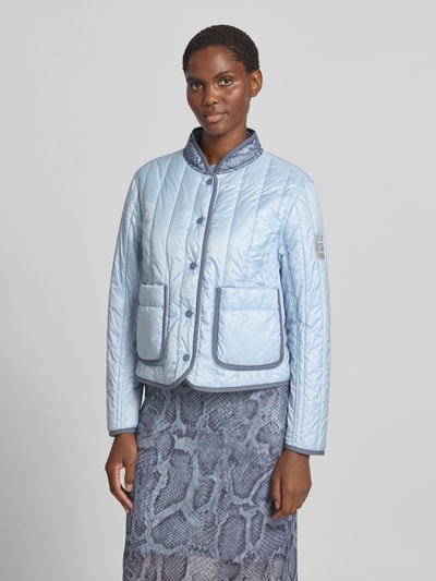 Frauenmodel trägt Regular Fit Jacke in Stepp-Optik mit Stehkragen von Marc Cain, hellblau, Allover-Schlangen-Print, Ganzkörperansicht von vorne.