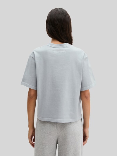 Kobiece modelka ma na sobie damski t-shirt Boxy Fit T-Shirt aus reiner Baumwolle von Marc O'Polo, efekt: jednolity kolor, z napisem z logo, okrągły dekolt, krótki rękaw, z bawełny, Ganzkörperansicht Rückansicht.
