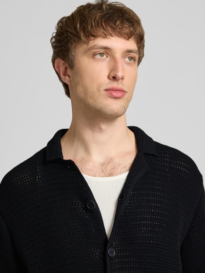 Männermodel trägt Regular Fit Freizeithemd aus reiner Baumwolle von Marc O'Polo Denim in Schwarz, strukturierte Strickoptik, Nahaufnahme Oberkörper.