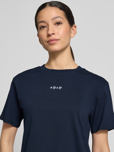Frauenmodel trägt Boxy Fit T-Shirt aus reiner Baumwolle von Tom Tailor Denim, dunkelblau, unifarben, Motiv-Stitching, Nahaufnahme Oberkörper.