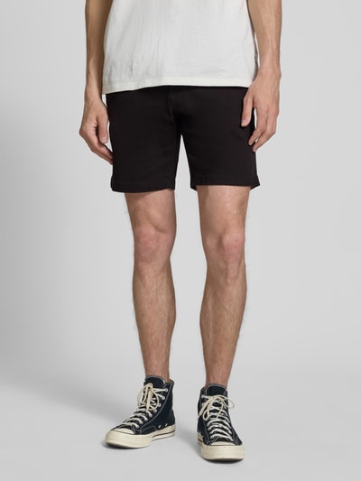 Männermodel trägt Straight Fit Shorts mit abnehmbarem Gürtel Modell 'Adam' von Jack & Jones, schwarze Baumwollmischung, Nahaufnahme Oberkörper. Elastischer Bund, Eingriff- und Gesäßtaschen, Knopf- und Reißverschluss, schlichte Textur.
