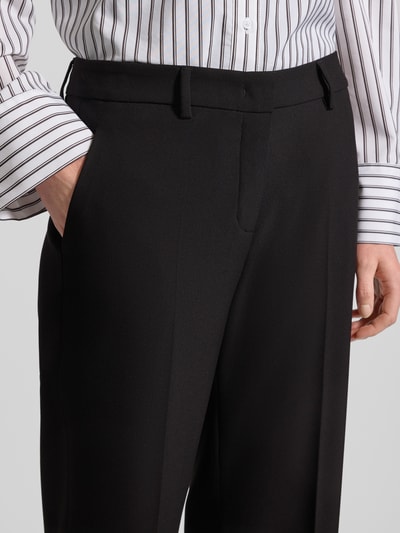 Frauenmodel trägt Wide Fit Stoffhose mit Viskose-Anteil Modell 'Olessa' von Raffaello Rossi in Crêpe, schwarze Bügelfalten, Nahaufnahme Oberkörper. Damen Stoffhose, Elastischer-Material-Mix, Haken- und Reißverschluss, Bundweite 41 cm, Innenbeinlänge 66 cm, glatte Struktur.