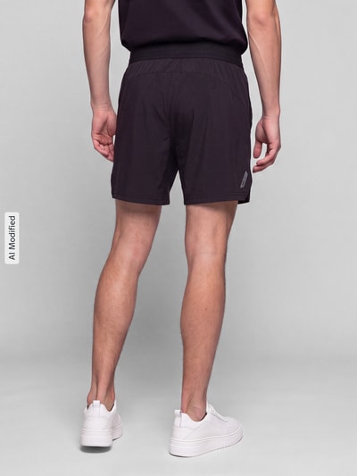 Männermodel trägt Regular Fit Sportshorts mit Logo-Print Modell 'M PWRMODE 5' von PUMA, dunkel, glatte Textur, Ganzkörperansicht Rückansicht, Herren Sportshorts von PUMA Performance, KI-modifiziertes Bild.