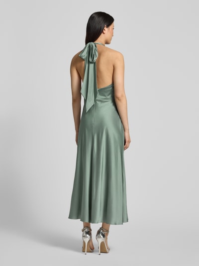 Modelka nosi Knielanges Cocktailkleid aus Satin od Hey Kyla, elastyczna mieszanka materiałów, dopasowany krój, satyna, marszczenia, krój bez rękawów, długość tyłu w rozmiarze 36: 97 cm, szerokość w rozmiarze 36: 38 cm, zielony kolor, gładka tekstura, widok całej sylwetki od tyłu.
