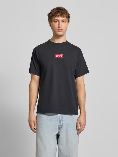 Męski model nosi T-shirt mit Label-Detail od LEVI'S®, czarny, bawełna, krój regular fit, okrągły dekolt, długość tyłu 68 cm, Ganzkörperansicht von vorne.