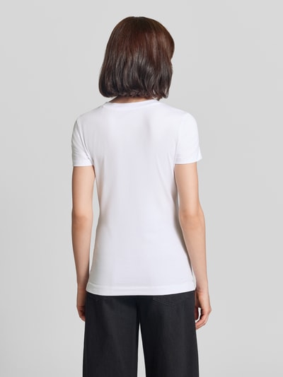 Frauenmodel trägt T-Shirt mit Ziersteinbesatz und Logo von GUESS, weiß, Slim Fit, Baumwoll-Elasthan-Mix, Rückansicht Ganzkörperansicht.