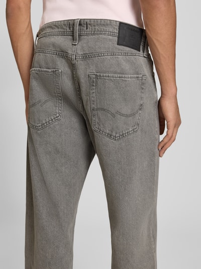 Männermodel trägt Straight Fit Jeans aus reiner Baumwolle Modell 'Eddie' von JACK & JONES in Grau, 5-Pocket-Design, Ganzkörperansicht Rückansicht.