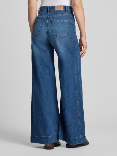 Kobieta modelka nosi Wide Leg Jeans mit Label-Detail Model 'Eila' od JOOP!, niebieska bawełna, wpuszczane kieszenie, detal z logo, Szerokość w rozmiarze 27: 38 cm, Długość wewnętrzna nogawki: 80 cm, widok całej sylwetki z tyłu.