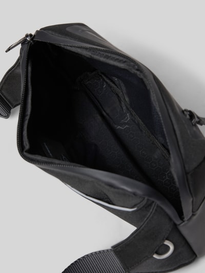 Produktfoto, Tasche mit Label-Detail von Porsche Design in Schwarz mit Hauptfach, Reißverschluss und Reflektorstreifen, texturierte Oberfläche