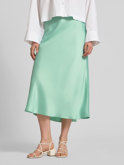 Kobieta nosi spódnicę midi z elastyczną mieszanką materiałów, linia a, model 'YASPELLA' od YAS, mięta, całkowita długość 83 cm, szerokość w rozmiarze s: 38 cm, z przodu widok całej sylwetki.