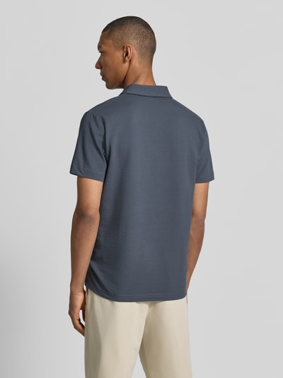 Männermodel trägt Regular Fit Poloshirt mit Logo-Stitching von Lerros in Blau mit Strukturmuster aus Baumwoll-Mix mit Stretch-Anteil, Ganzkörperansicht Rückansicht.