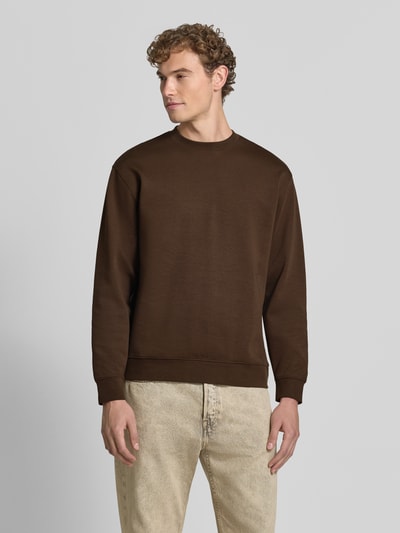 Mannelijk model draagt bruine slim fit pullover van katoen 'TOM' van Selected, heren sweatshirt, geheellichaamsaanzicht van voren.