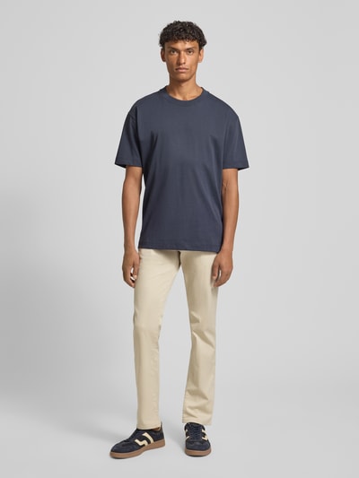 Männermodel trägt Hose im 5-Pocket-Design Modell 'CORDOBA' von bugatti aus beigem Baumwoll-Mix, Straight Fit, Ganzkörperansicht von vorne.