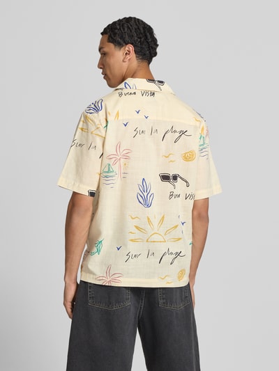 Männermodel trägt Relaxed Fit Freizeithemd aus reiner Baumwolle Modell 'LUKE' von Only & Sons für Herren, hellgelb mit buntem Print, Ganzkörperansicht Rückansicht.