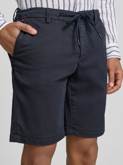 Männermodel trägt Bermudas mit Bindegürtel und französischen Eingrifftaschen von MAC aus Baumwoll-Mix mit Stretch-Anteil, Nahaufnahme Oberschenkel.