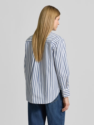 Vrouwenmodel draagt Loose Fit Hemdbluse aus reiner Baumwolle van Tommy Hilfiger met all-over gestreept motief, afgeronde rompzoom, borstzak, fijne geweven structuur, gestikt logo, lange mouwen met manchet, overhemdkraag, knoopsluiting, puur katoen, Ganzkörperansicht Rückansicht.