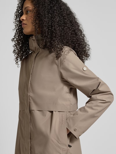 Vrouwenmodel draagt Regular fit functioneel jack met capuchon model 'Elsa' van Didriksons, kleur taupe, opstaande kraag, steekzakken, ruglengte 74 cm, schouderbreedte 42 cm, borstwijdte 37 cm, mouwlengte 63 cm, detailopname bovenlichaam.