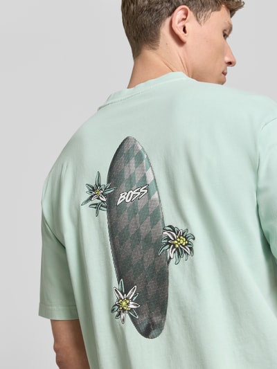 Männermodel trägt Regular Fit T-Shirt aus reiner Baumwolle Modell 'SURFWASH' von BOSS Orange in Optik: Unifarben mit Label-Print, Nahaufnahme Rückansicht.