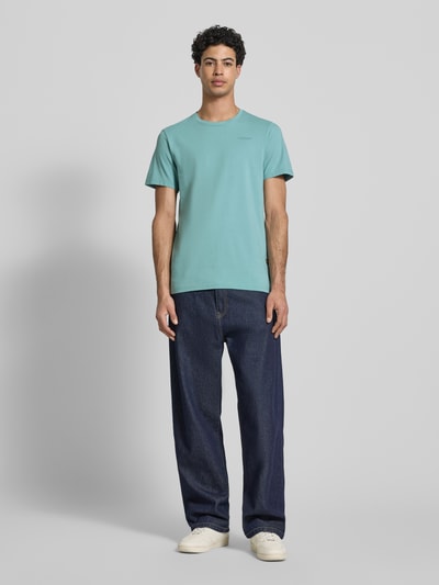 Männermodel trägt Slim Fit T-Shirt mit Logo-Stitching von G-Star Raw in Mintgrün, elastischer Baumwoll-Mix, Ganzkörperansicht von vorne