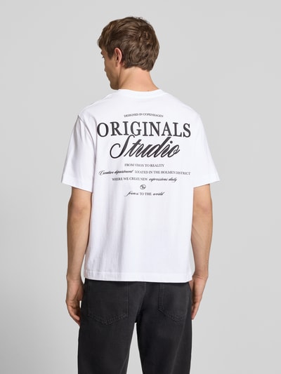 Männermodel trägt T-shirt met statementprint model 'NORREBRO' van Jack & Jones, puur katoen, recht model, ronde hals, ruglengte maat M 68 cm, Ganzkörperansicht Rückansicht.
