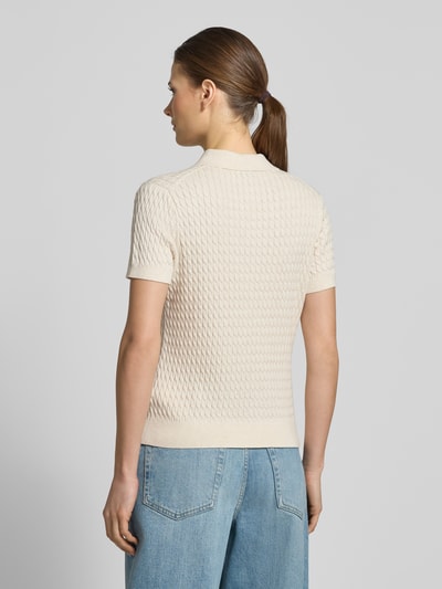 Vrouwenmodel draagt 'Slim Fit Poloshirt uit puur katoen' van Tommy Hilfiger in effen kleur met kabelpatroon, gebreide knitwear, romp- en mouwboord, logodetail, polokraag, v-hals, korte knoopsluiting, korte mouw, achteraanzicht volledige lichaamsopname.
