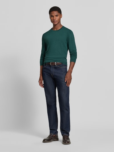 Männermodel trägt Strickpullover mit geripptem Rundhalsausschnitt von MCNEAL in Dunkelgrün, taillierte Passform, Ganzkörperansicht von vorne.