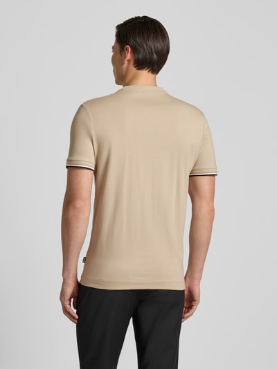 Männermodel trägt Regular Fit T-Shirt aus reiner Baumwolle Modell 'THOMPSON' von BOSS in Beige mit Kontraststreifen, unifarben, Ganzkörperansicht Rückansicht.