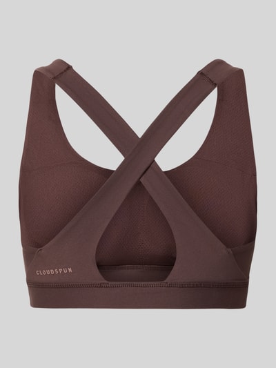 Frauenmodel trägt Slim Fit Sportbh mit Logo-Print Modell 'Cloudspun' von PUMA, Elastischer-Material-Mix, Cut-Out auf der Rückseite, Ganzkörperansicht Rückansicht