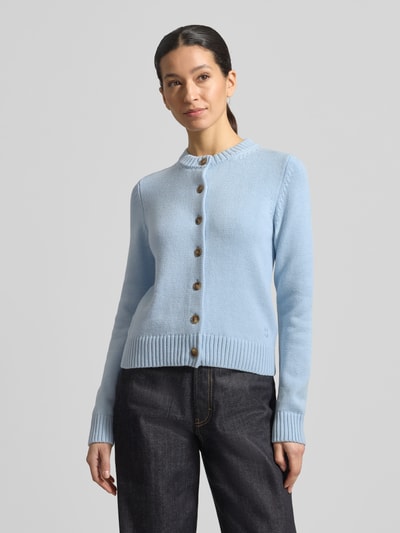 Modelka kobieca ma na sobie Kardigan rozpinany z okrągłym dekoltem i listwą guzikową od Jake*s Casual, mieszanka bawełny, krój regular fit, długość tyłu w rozmiarze S: 53 cm, długość rękawów w rozmiarze S: 65 cm, jasnoniebieski, prosta faktura dzianiny, widoczna listwa guzikowa, gładki materiał, widoczne ściągacze, zdjęcie całej sylwetki z przodu.