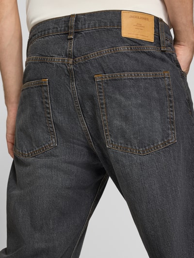 Männermodel trägt Wide Fit Jeans aus reiner Baumwolle Modell 'Ted' von JACK & JONES, dunkles Denim, sichtbare Nähte, Nahaufnahme Rückansicht. 5-Pocket-Design, Knopf- und Reißverschluss, Bundweite 84 cm, Innenbeinlänge 75 cm.