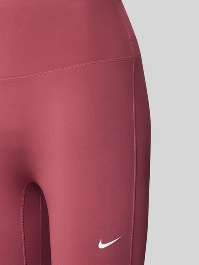 Vrouwenmodel draagt Slim Fit Leggings met logo-print en hoge band model 'One' van Nike, Dames sport-legging, detailopname.