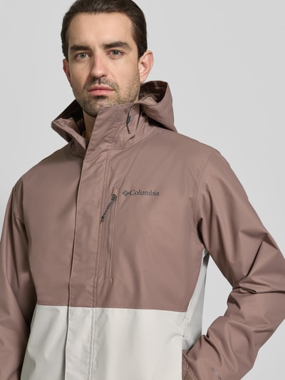 Männermodel trägt Jacke mit capuchon Model 'Hikebound™ II' van Columbia in regular fit, met tunnelkoord, logoprint, mouwsluitingen, nahaufnahme oberkörper. Ruglengte maat M: 74 cm, schouderbreedte: 49 cm, borstwijdte: 61 cm, mouwlengte: 70 cm.